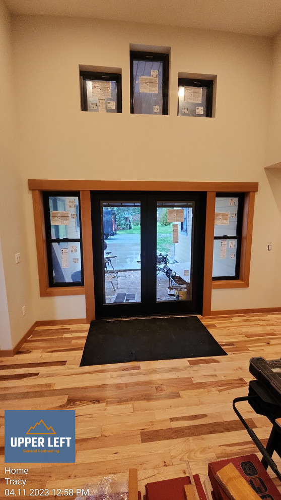 Inspiration for a mid-sized arts and crafts front door in Seattle with white walls, light hardwood floors, a double front door, a black front door and vaulted.