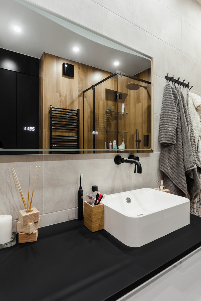 Mid-sized contemporary 3/4 wet room bathroom in Moscow with flat-panel cabinets, light wood cabinets, a wall-mount toilet, gray tile, wood-look tile, black walls, porcelain floors, a vessel sink, solid surface benchtops, grey floor, a hinged shower door, black benchtops and a single vanity.