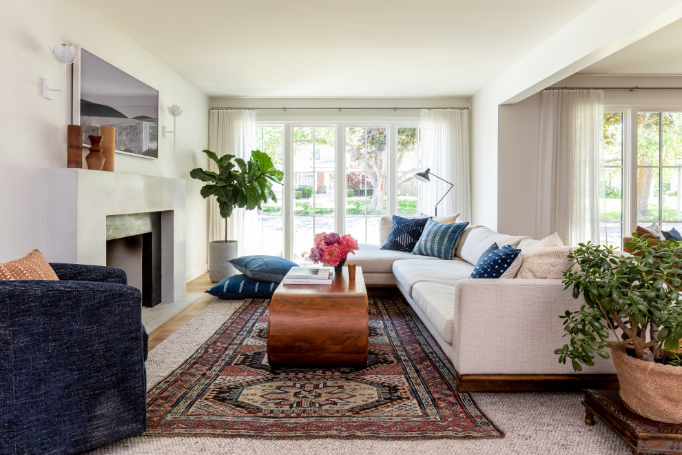 Offenes Klassisches Wohnzimmer mit weißer Wandfarbe, braunem Holzboden, Kamin, TV-Wand und braunem Boden