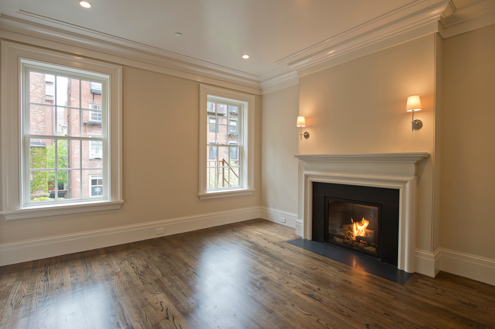 Large traditional open concept living room in Boston with beige walls, medium hardwood floors and a standard fireplace.