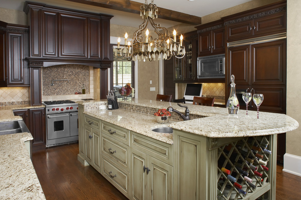 This is an example of a country kitchen in Atlanta with panelled appliances, raised-panel cabinets, dark wood cabinets and granite benchtops.