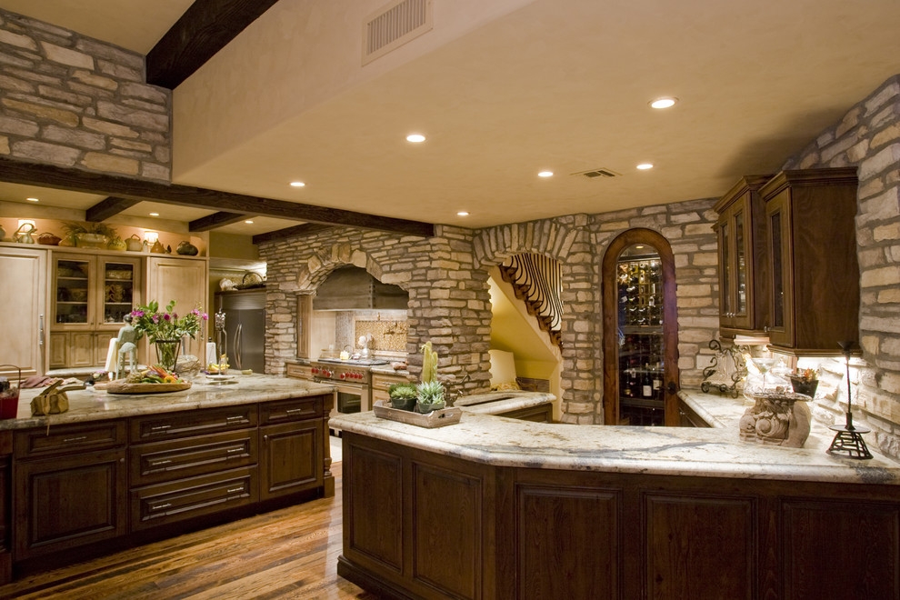 Design ideas for a mediterranean kitchen in Phoenix with raised-panel cabinets and dark wood cabinets.