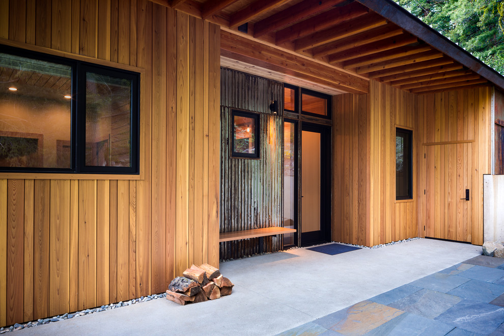 Inspiration for a mid-sized country front yard verandah in Seattle with concrete slab and a roof extension.