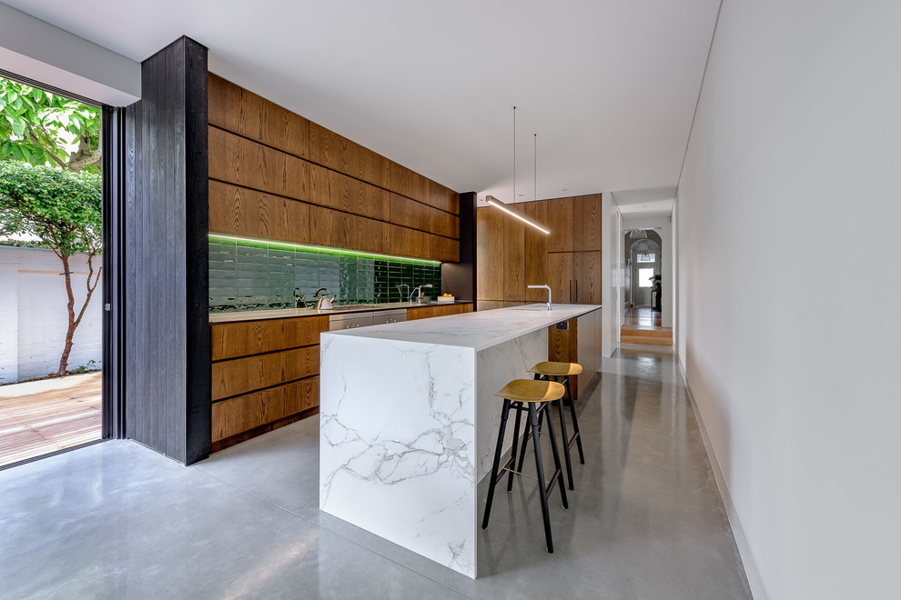 Photo of a small contemporary galley kitchen in Sydney with marble benchtops, green splashback, ceramic splashback, stainless steel appliances, concrete floors, with island, grey floor, white benchtop, flat-panel cabinets and medium wood cabinets.