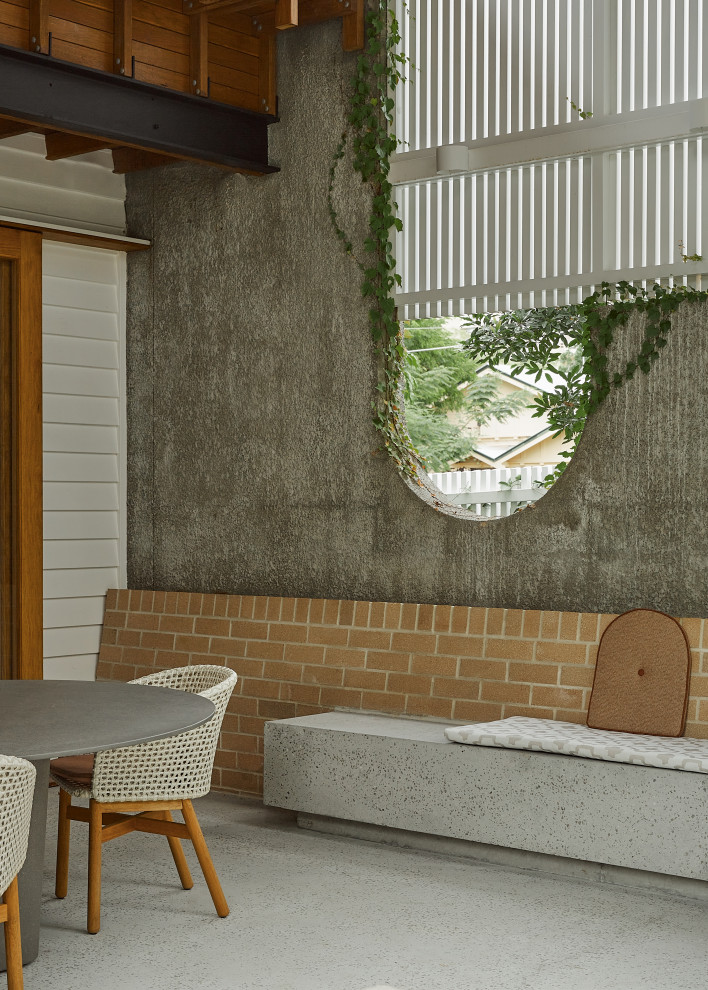 Ispirazione per un patio o portico design dietro casa con lastre di cemento