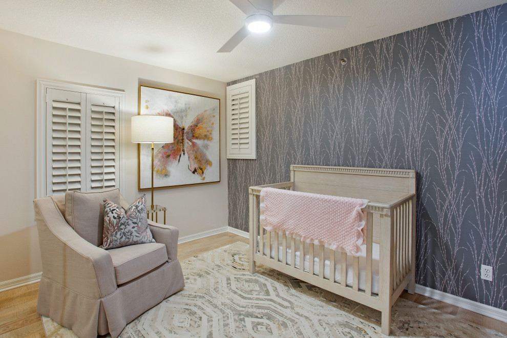 Idee per una cameretta per neonata tradizionale di medie dimensioni con pareti grigie, parquet chiaro, pavimento beige e carta da parati