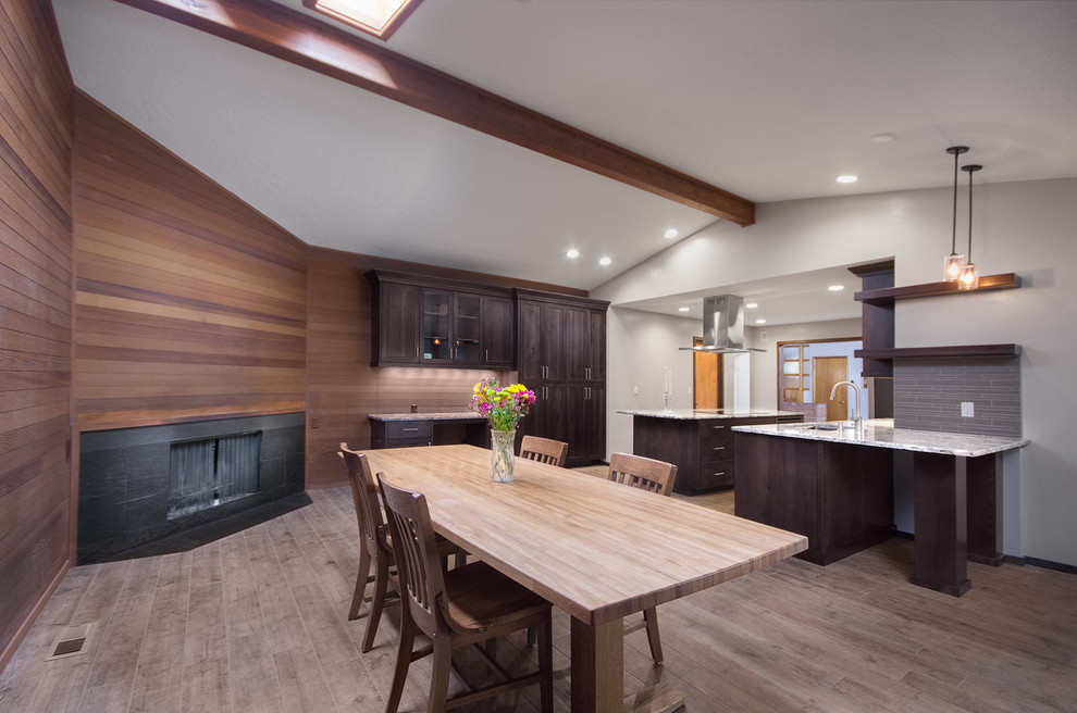 Large contemporary kitchen/dining combo in Boise with porcelain floors, white walls, a corner fireplace and a wood fireplace surround.