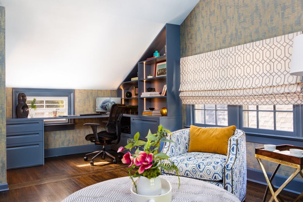 Inredning av ett klassiskt mellanstort arbetsrum, med blå väggar, mellanmörkt trägolv, ett inbyggt skrivbord och brunt golv