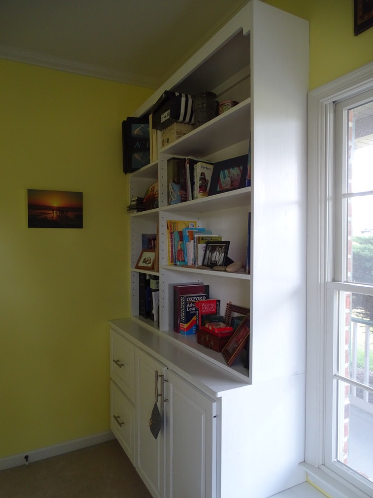 Example of a mid-sized classic freestanding desk carpeted and beige floor home office library design with yellow walls and no fireplace