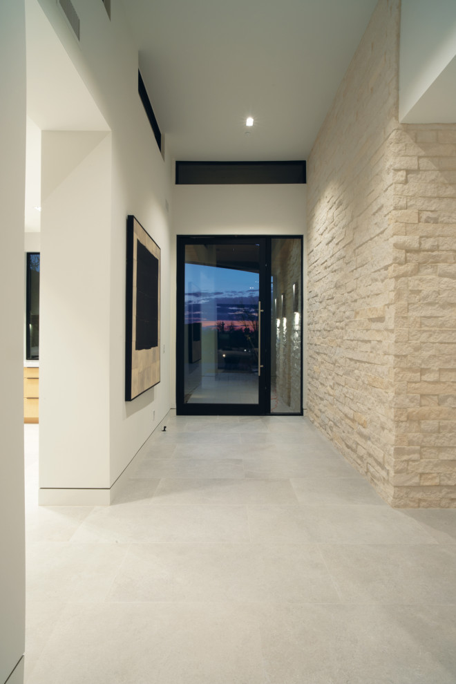 Photo of a contemporary front door in Phoenix with white walls, a single front door, a glass front door and brick walls.