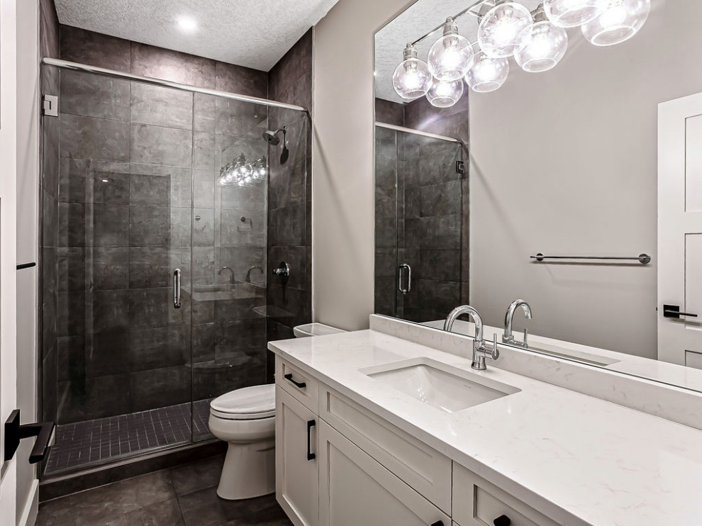 Transitional 3/4 white tile and ceramic tile light wood floor, gray floor and single-sink corner shower photo in Calgary with shaker cabinets, white cabinets, a two-piece toilet, gray walls, an undermount sink, quartz countertops, a hinged shower door, white countertops and a built-in vanity