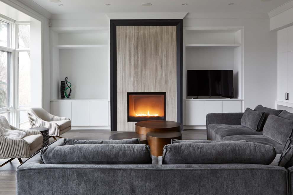 Inspiration for a mid-sized contemporary enclosed family room in Toronto with white walls, dark hardwood floors, a standard fireplace, a wood fireplace surround and a freestanding tv.