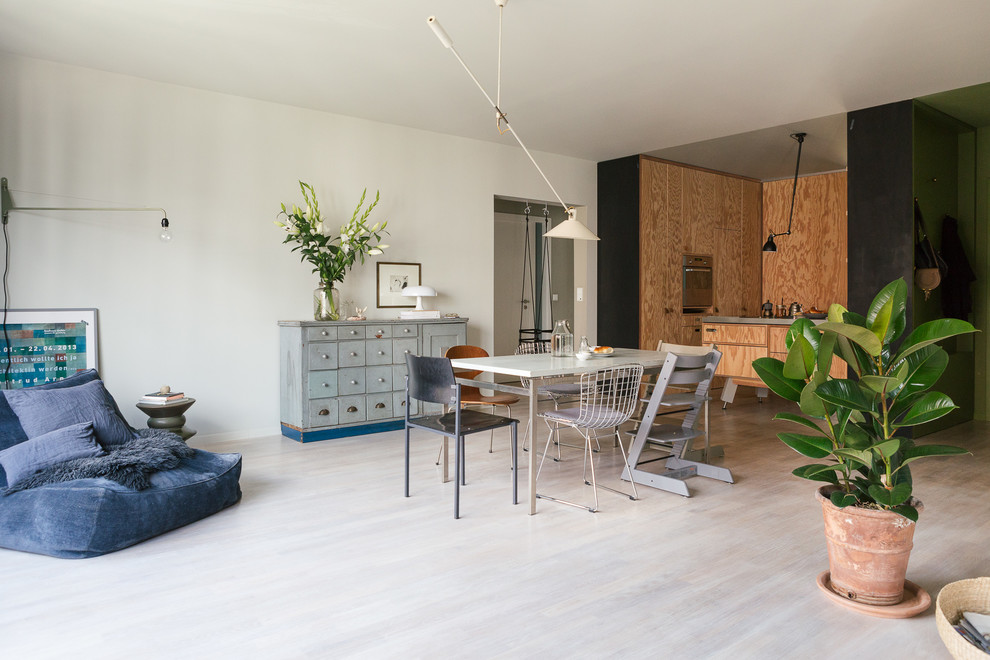 Mid-sized eclectic open plan dining in Berlin with white walls and light hardwood floors.