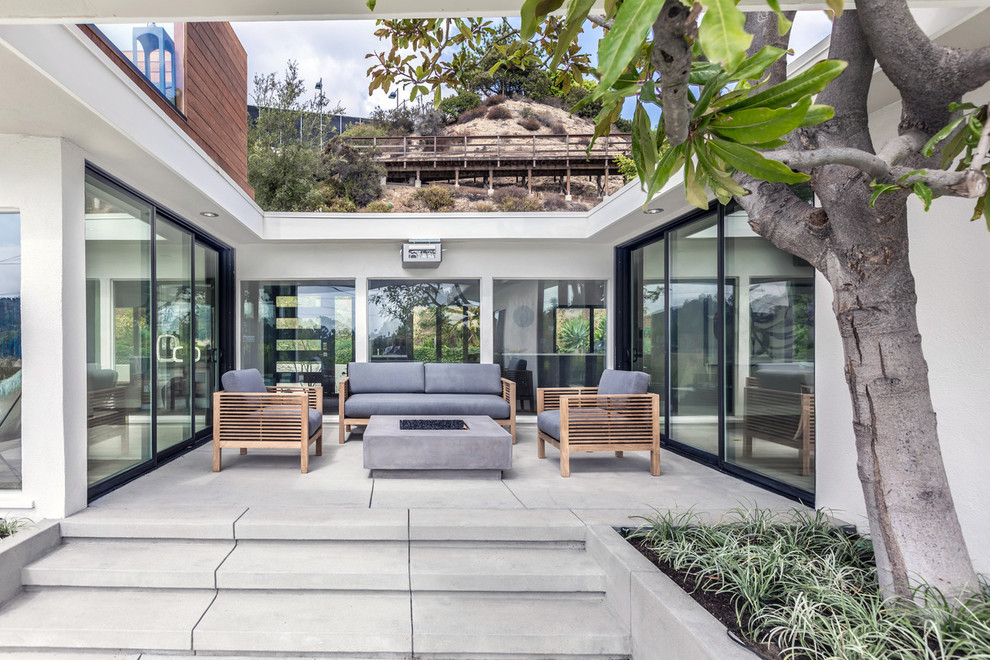 Mid-sized midcentury patio in Los Angeles with a fire feature and decking.