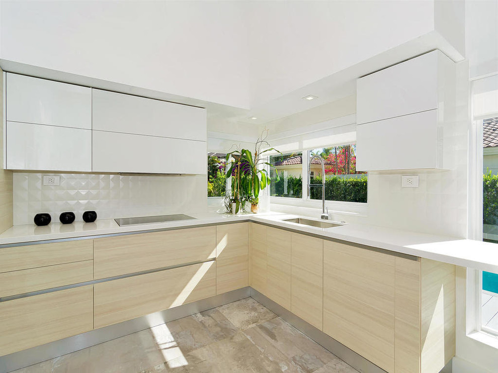 Photo of a large modern u-shaped eat-in kitchen in Miami with an undermount sink, flat-panel cabinets, white cabinets, quartz benchtops, white splashback, ceramic splashback, stainless steel appliances, porcelain floors, no island, grey floor and white benchtop.
