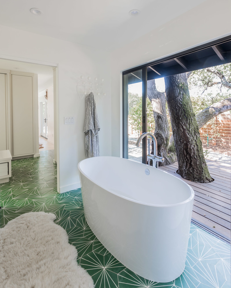 Inspiration for a midcentury master bathroom in San Francisco with a freestanding tub, cement tiles, green floor and white walls.