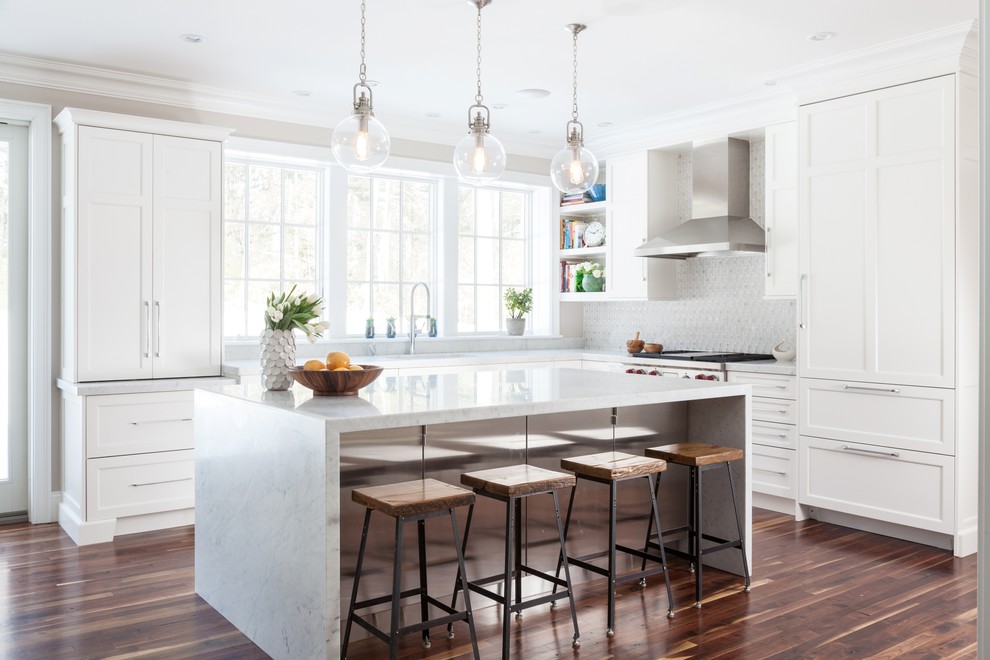 Photo of a transitional l-shaped eat-in kitchen in Boston with recessed-panel cabinets, white cabinets, white splashback, panelled appliances, an undermount sink, marble benchtops, mosaic tile splashback, medium hardwood floors and with island.
