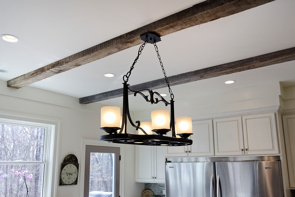 Inspiration for a transitional u-shaped open concept kitchen remodel with a farmhouse sink, raised-panel cabinets, white cabinets, soapstone countertops, multicolored backsplash and stainless steel appliances