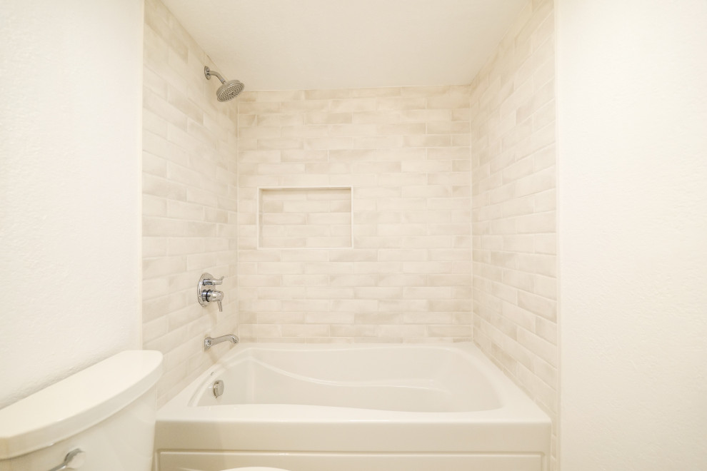 This is an example of a mid-sized master bathroom in Los Angeles with raised-panel cabinets, white cabinets, an undermount tub, an open shower, a one-piece toilet, white tile, ceramic tile, beige walls, medium hardwood floors, a drop-in sink, tile benchtops, beige floor, an open shower, white benchtops, a niche, a single vanity and a freestanding vanity.