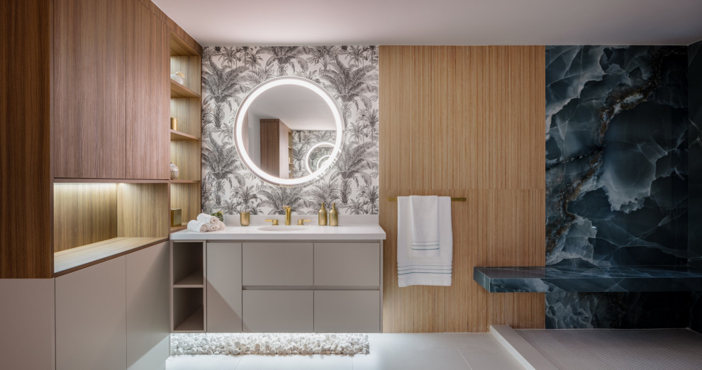 Источник вдохновения для домашнего уюта: огромная главная ванная комната в стиле модернизм с плоскими фасадами, серыми фасадами, открытым душем, унитазом-моноблоком, разноцветной плиткой, керамогранитной плиткой, полом из керамогранита, врезной раковиной, столешницей из искусственного кварца, серым полом, открытым душем, белой столешницей, сиденьем для душа, тумбой под одну раковину, подвесной тумбой и обоями на стенах