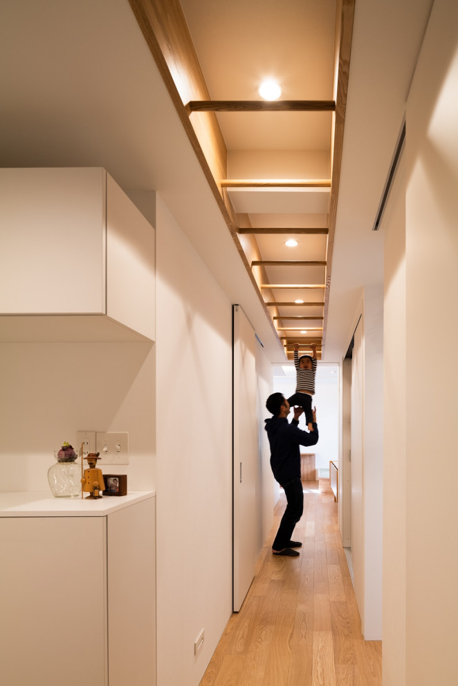 На фото: коридор среднего размера в скандинавском стиле с белыми стенами, полом из фанеры, многоуровневым потолком и обоями на стенах