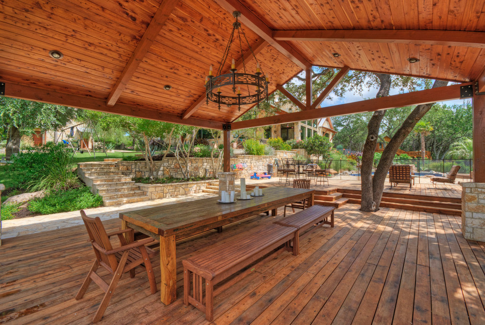 This is an example of a country backyard patio in Austin with a gazebo/cabana and decking.