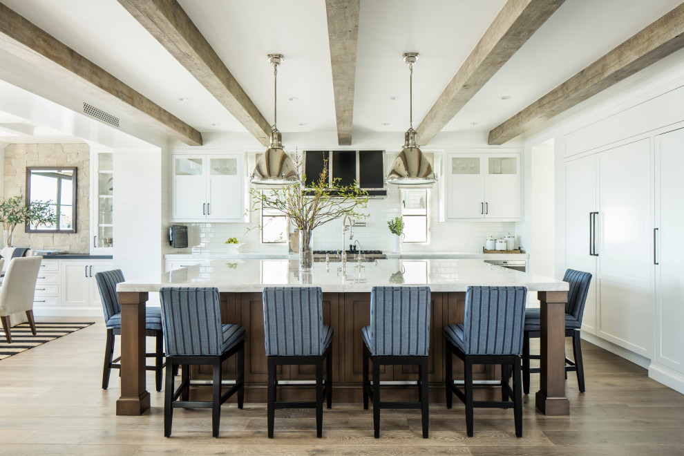 Inspiration for a beach style single-wall eat-in kitchen in Orange County with white cabinets and with island.