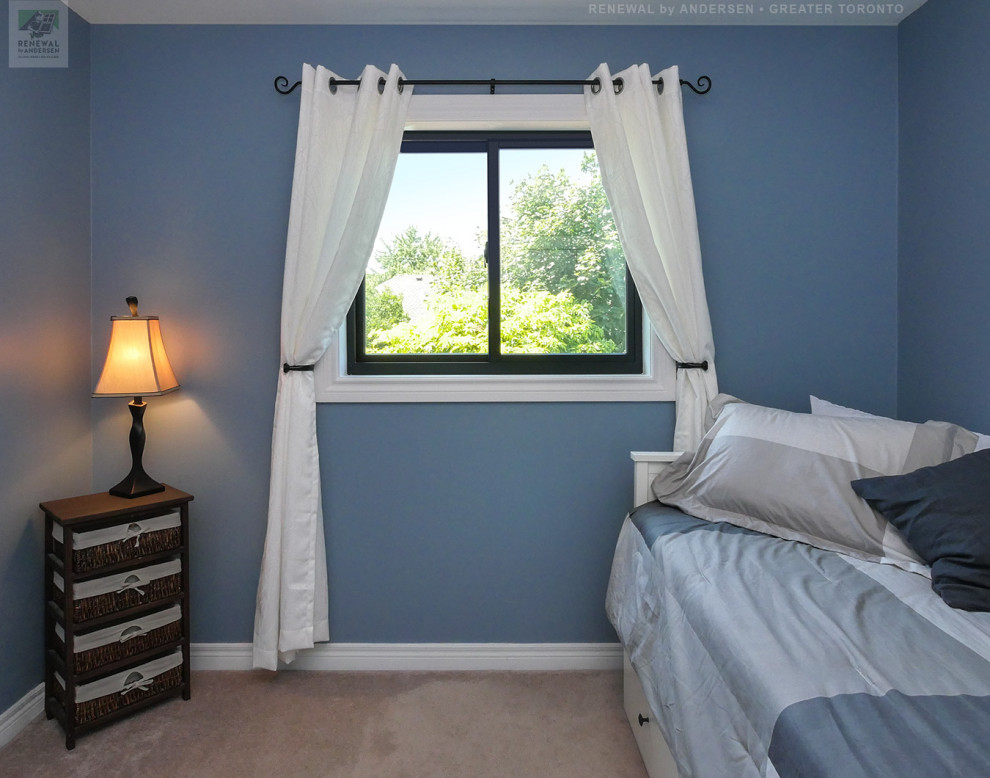 This is an example of a small guest bedroom in Toronto with blue walls, carpet, no fireplace and beige floors.