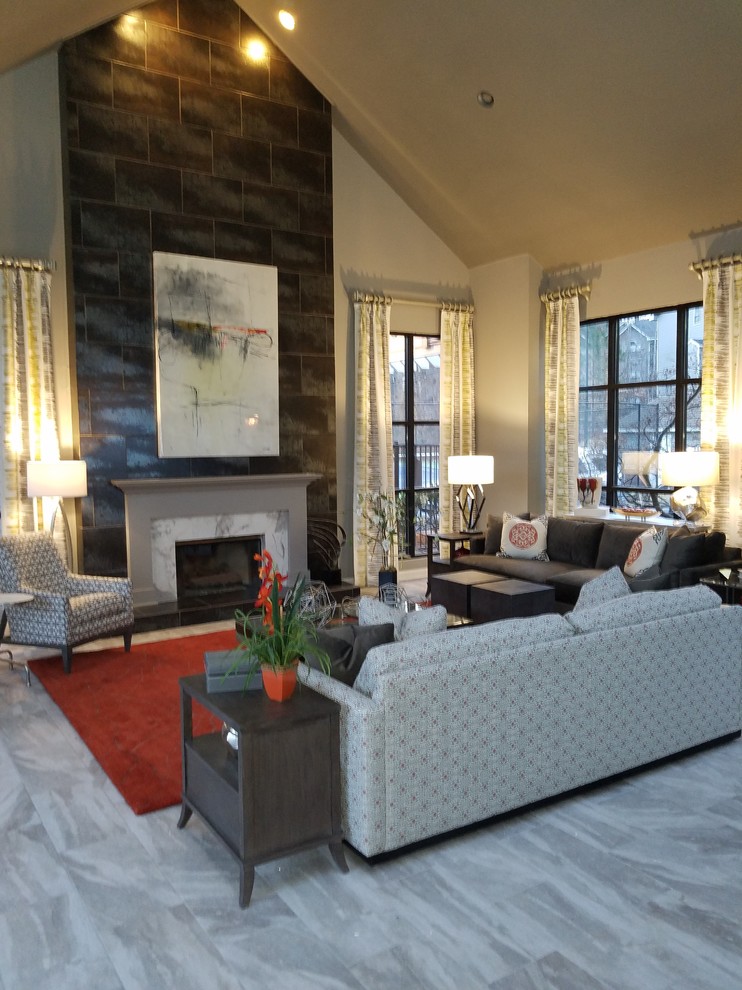 This is an example of a large asian open concept living room in Atlanta with grey walls, porcelain floors, a standard fireplace, a tile fireplace surround, a wall-mounted tv and grey floor.
