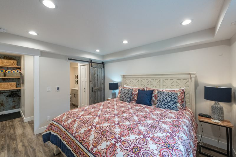 Photo of a medium sized scandinavian guest bedroom in Salt Lake City with beige walls, laminate floors, multi-coloured floors and a drop ceiling.