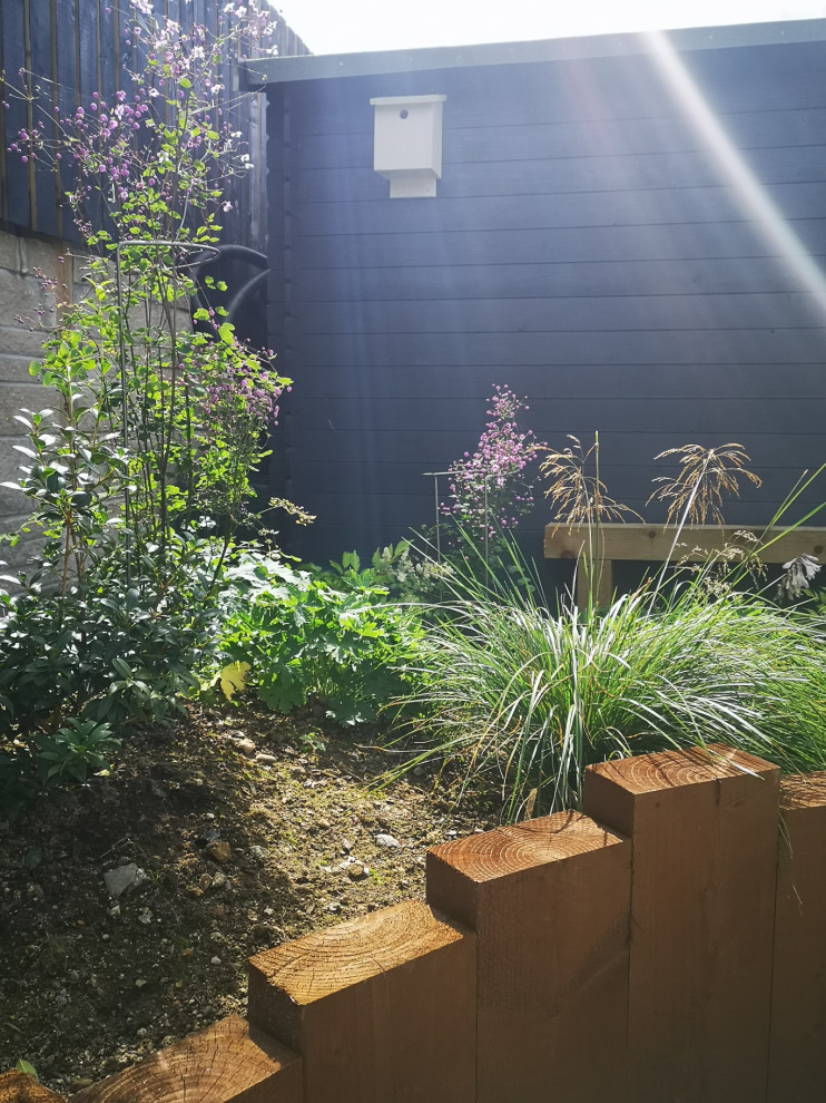 Bild på en mellanstor funkis trädgård i delvis sol på sommaren
