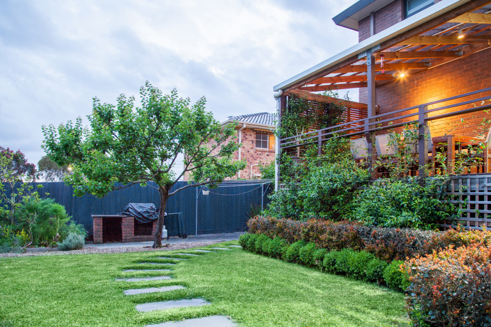 Mid-sized contemporary backyard full sun garden in Melbourne with a vertical garden, natural stone pavers and a wood fence for spring.