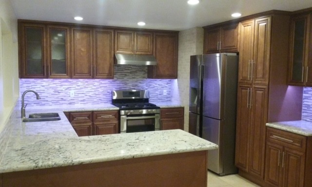 Inspiration for a mid-sized transitional u-shaped ceramic tile eat-in kitchen remodel in Orange County with raised-panel cabinets, medium tone wood cabinets, multicolored backsplash, matchstick tile backsplash, stainless steel appliances and a peninsula