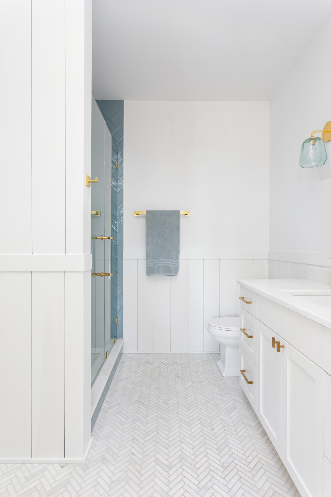 Mid-sized beach style kids bathroom in Charleston with furniture-like cabinets, blue cabinets, a corner shower, a two-piece toilet, mosaic tile, white walls, mosaic tile floors, an integrated sink, white floor, a hinged shower door, white benchtops, a double vanity and a built-in vanity.
