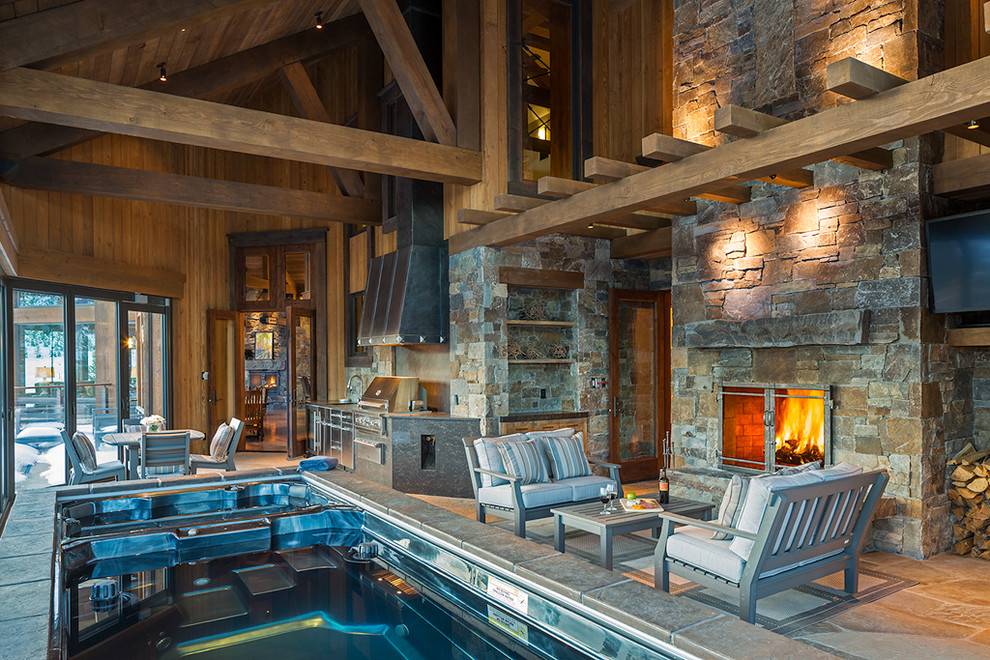 Large mountain style indoor stone and rectangular lap pool house photo