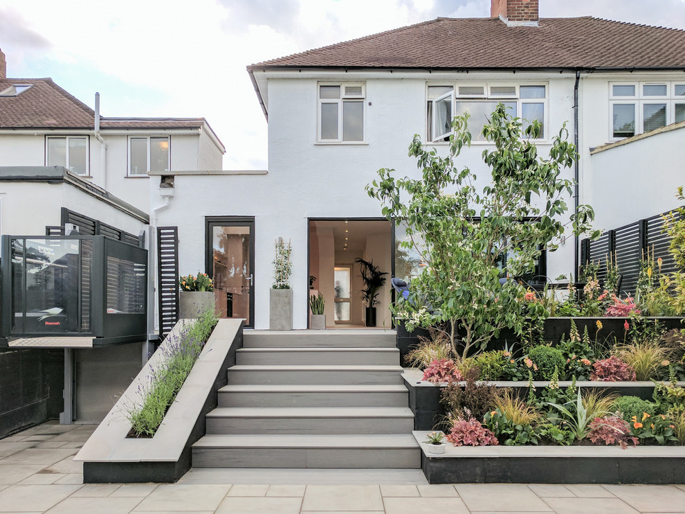 Inspiration for a mid-sized contemporary two-storey stucco white duplex exterior in London.