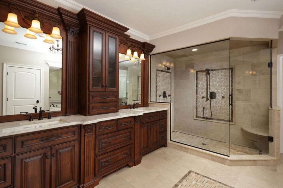 Inspiration for a large transitional master bathroom in Other with limestone, raised-panel cabinets, dark wood cabinets, a claw-foot tub, an alcove shower, a one-piece toilet, beige walls, limestone floors, an undermount sink, granite benchtops, beige floor and a hinged shower door.