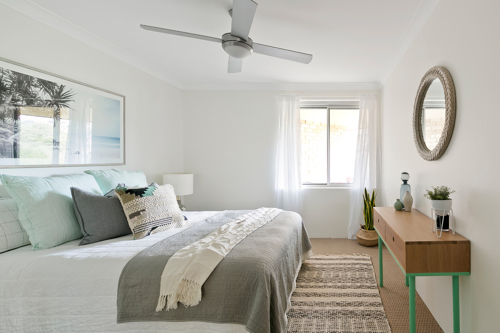Photo of a mid-sized beach style guest bedroom in Sydney with white walls, carpet and beige floor.
