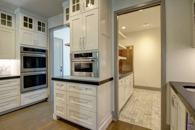 Enclosed kitchen - large contemporary l-shaped medium tone wood floor enclosed kitchen idea in Other with an undermount sink, beaded inset cabinets, white cabinets, granite countertops, white backsplash, stone slab backsplash, stainless steel appliances and an island