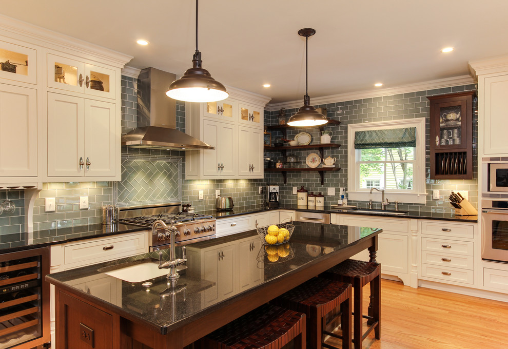 Design ideas for a large traditional l-shaped eat-in kitchen in Raleigh with an undermount sink, shaker cabinets, beige cabinets, granite benchtops, blue splashback, glass tile splashback, stainless steel appliances, medium hardwood floors, with island and beige floor.