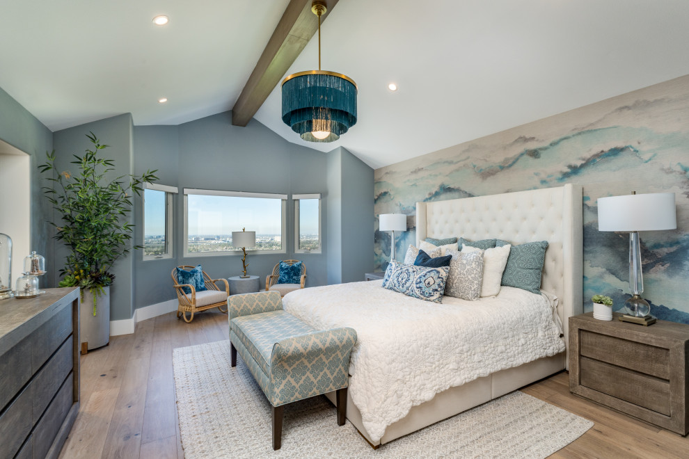 Photo of a medium sized coastal master bedroom in Orange County with blue walls, light hardwood flooring, beige floors, a vaulted ceiling and wallpapered walls.