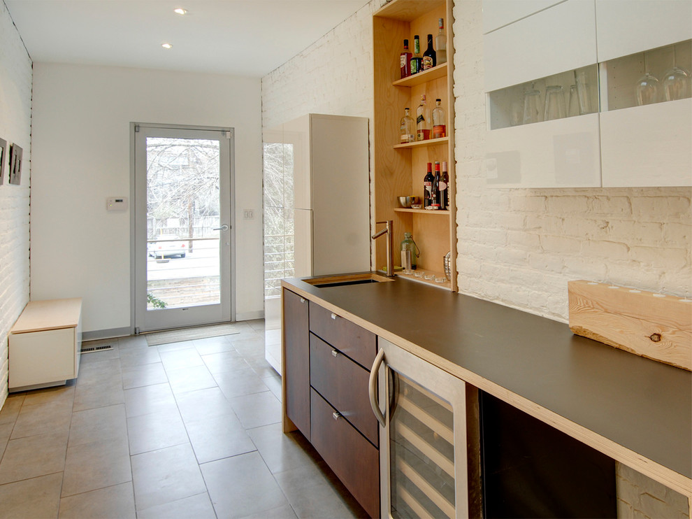 This is an example of a mid-sized contemporary single-wall wet bar in Richmond with an undermount sink, flat-panel cabinets, medium wood cabinets, laminate benchtops, white splashback and porcelain floors.