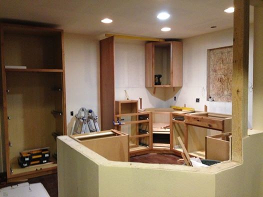 Mid-sized mountain style u-shaped dark wood floor eat-in kitchen photo in Denver with an undermount sink, flat-panel cabinets, light wood cabinets, granite countertops, green backsplash, glass tile backsplash, stainless steel appliances and a peninsula