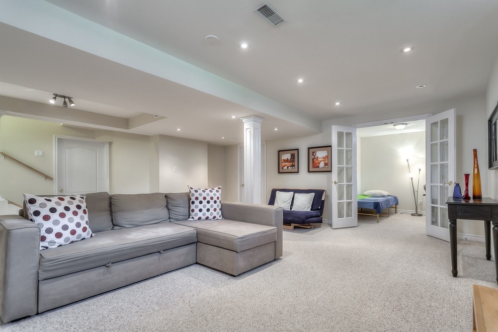 Example of a large transitional underground carpeted basement design in Toronto with white walls