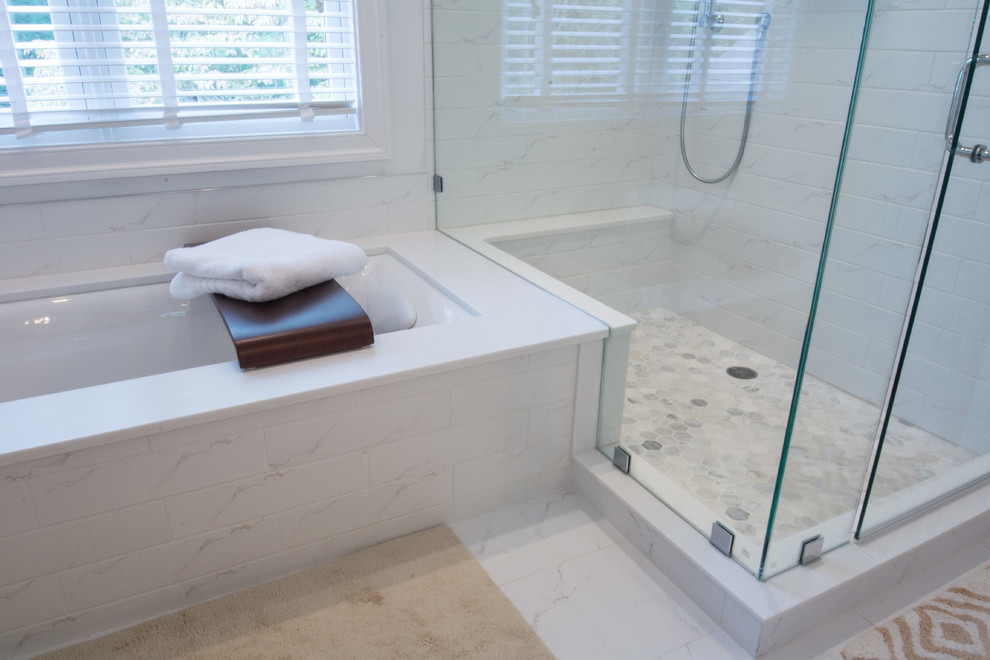 Design ideas for a mid-sized transitional master bathroom in Philadelphia with raised-panel cabinets, white cabinets, an undermount tub, a corner shower, white tile, stone tile, white walls, marble floors, an undermount sink, solid surface benchtops, white floor, a hinged shower door and white benchtops.