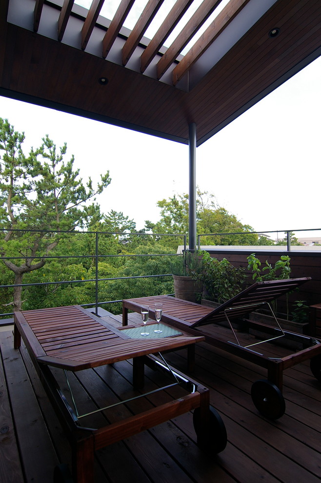 This is an example of a midcentury balcony in Other with a pergola and metal railing.