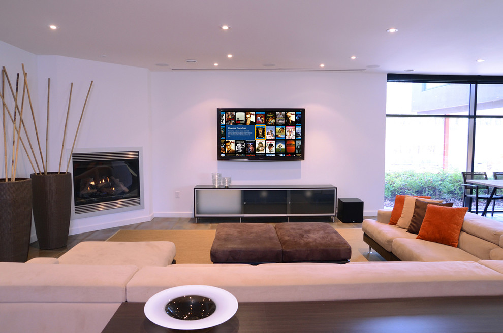 Photo of a large contemporary family room in Toronto with white walls, a corner fireplace, a wall-mounted tv and a metal fireplace surround.