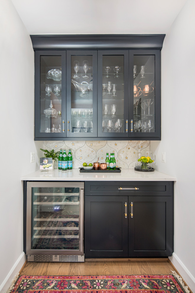 Inspiration for a contemporary home bar in DC Metro with no sink, recessed-panel cabinets, black cabinets, beige splashback, ceramic splashback and white benchtop.