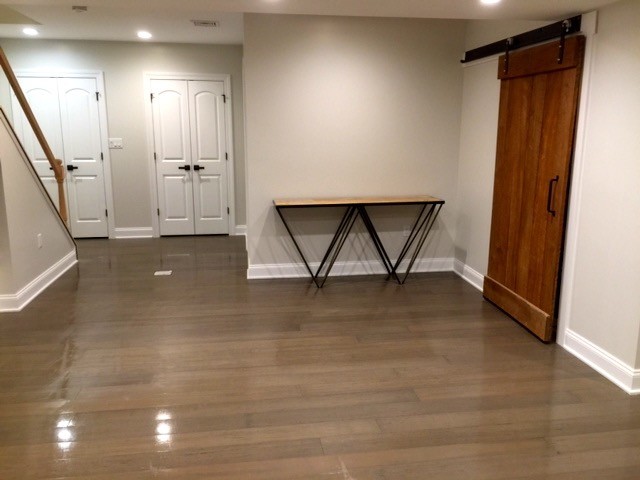 Inspiration for a mid-sized transitional underground dark wood floor and brown floor basement remodel with beige walls and no fireplace