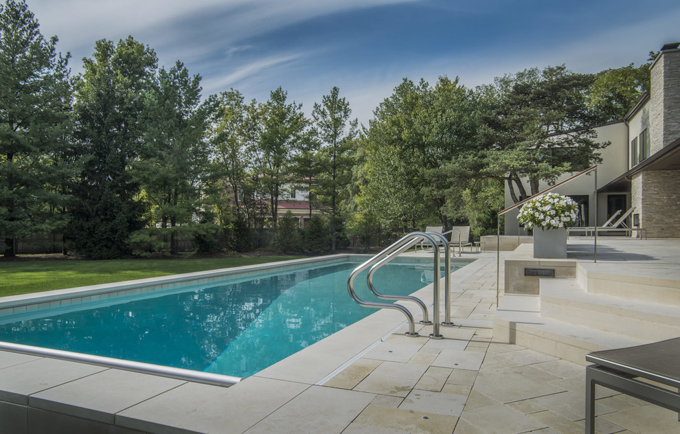 Pool - mid-sized modern backyard stone and rectangular pool idea in Chicago